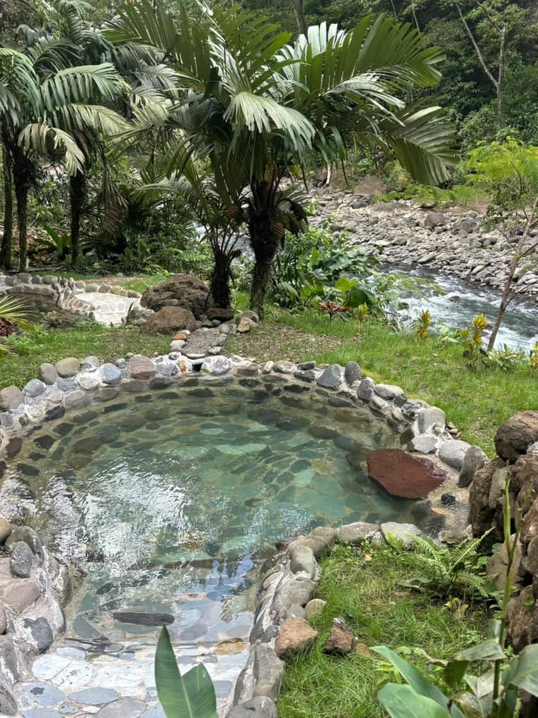 Terraza de pozas termales de piedra junto al río, entre la selva